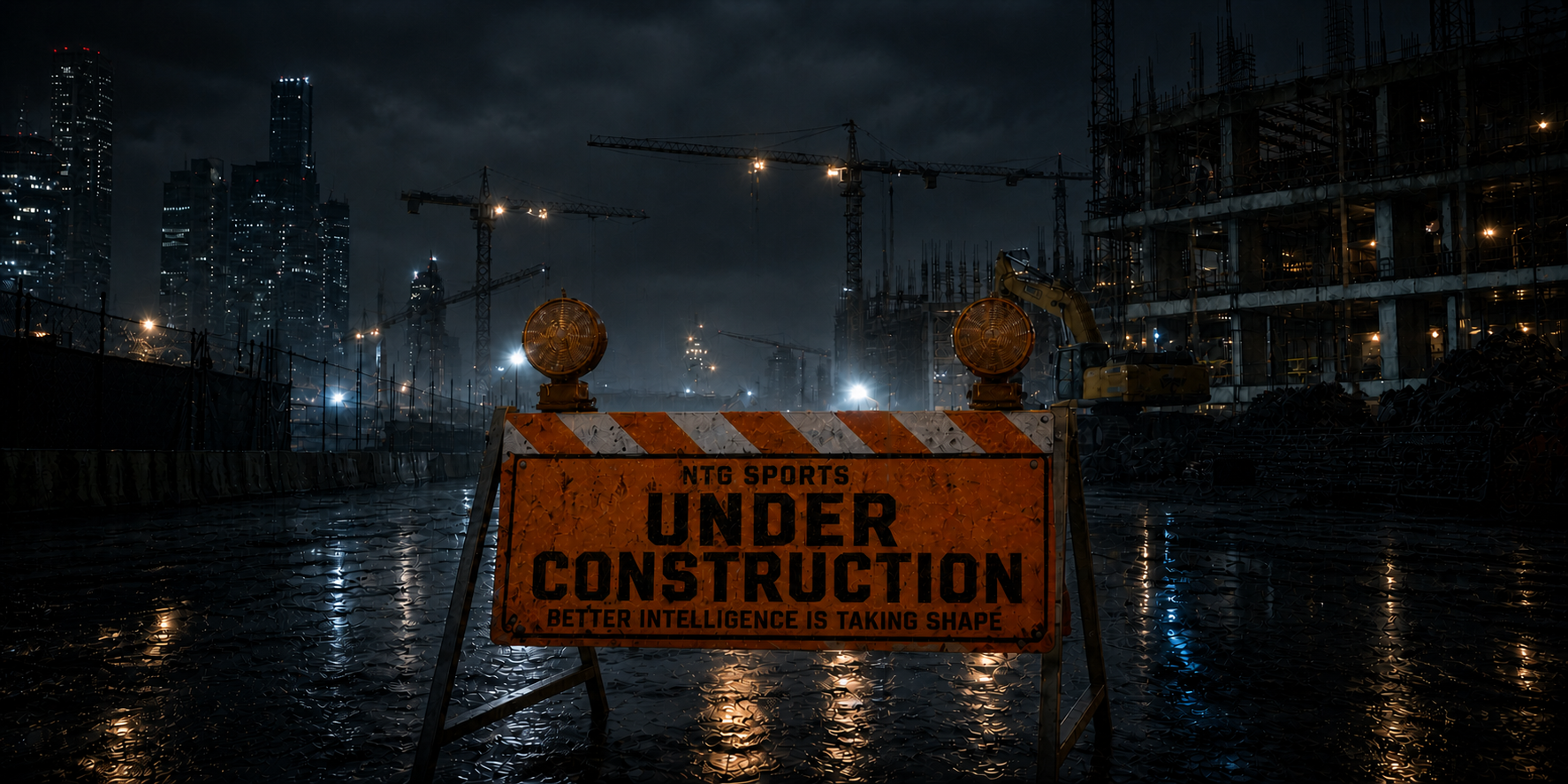 Wet nighttime construction site with cranes, machinery and an NTG Sports under-construction barricade